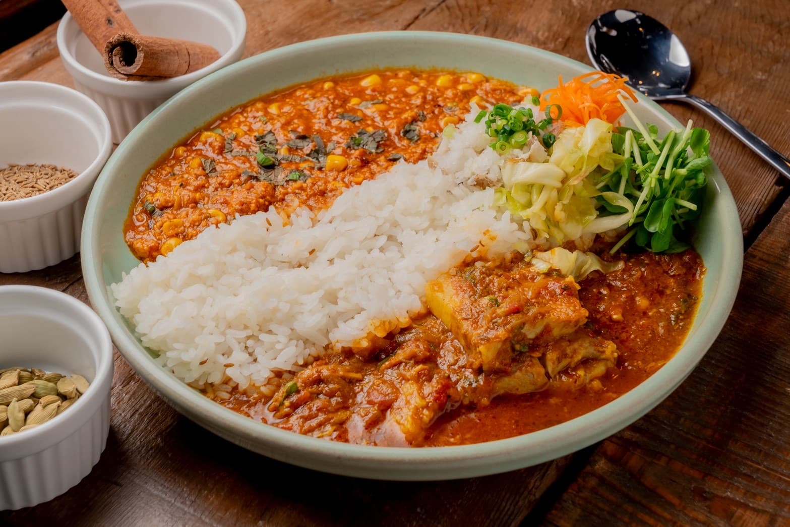 マル志のスパイスカレー。2種のあいがけに副菜が添えられた一皿