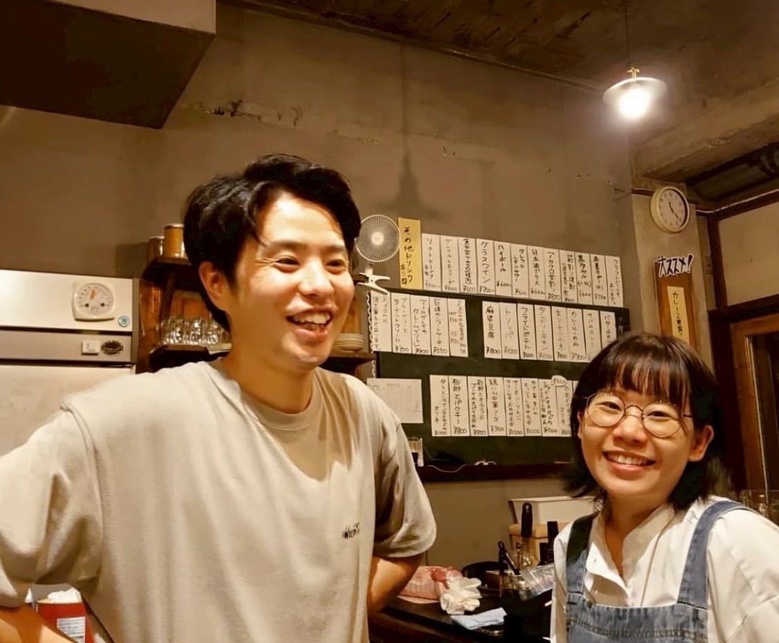 カウンター越しに笑う店主の山田祐太さんとひかりさん